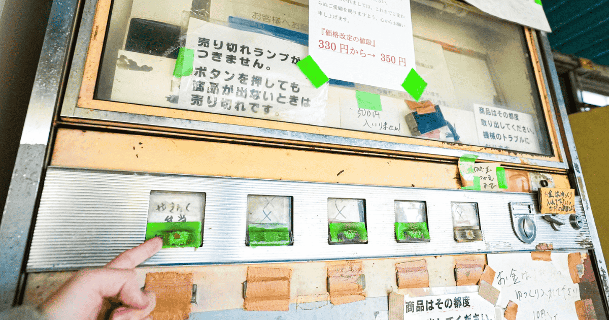 レトロ自販機のボタンを押そうとしている